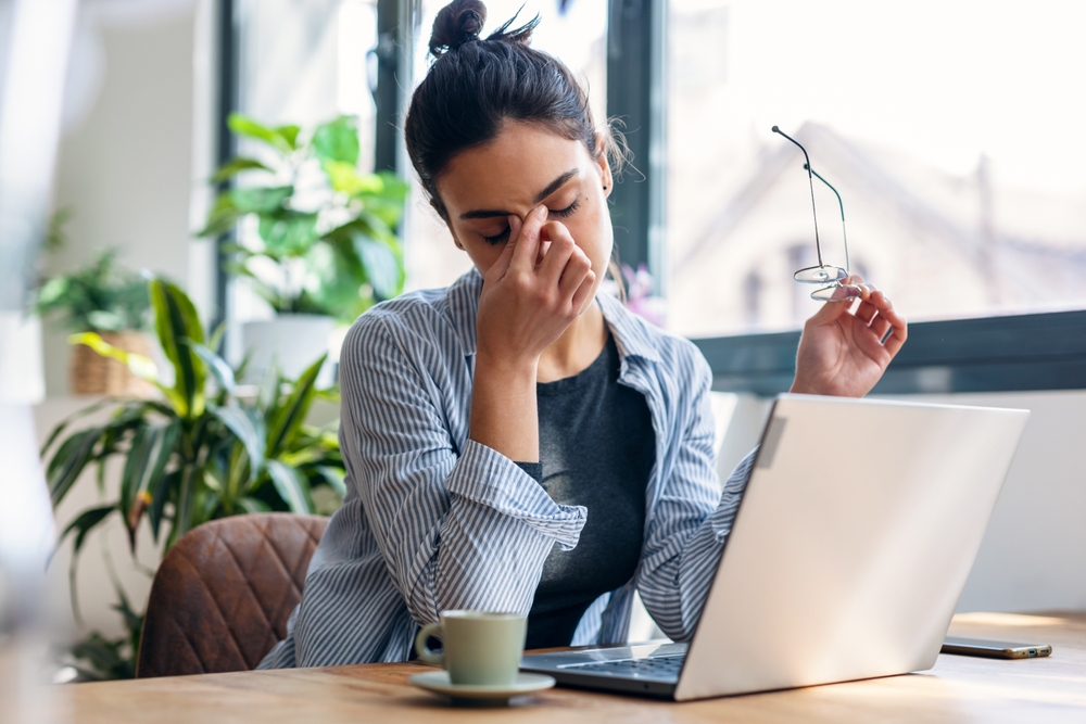 Shot of stressed business woman working from home on laptop looking worried, tired and overwhelmed